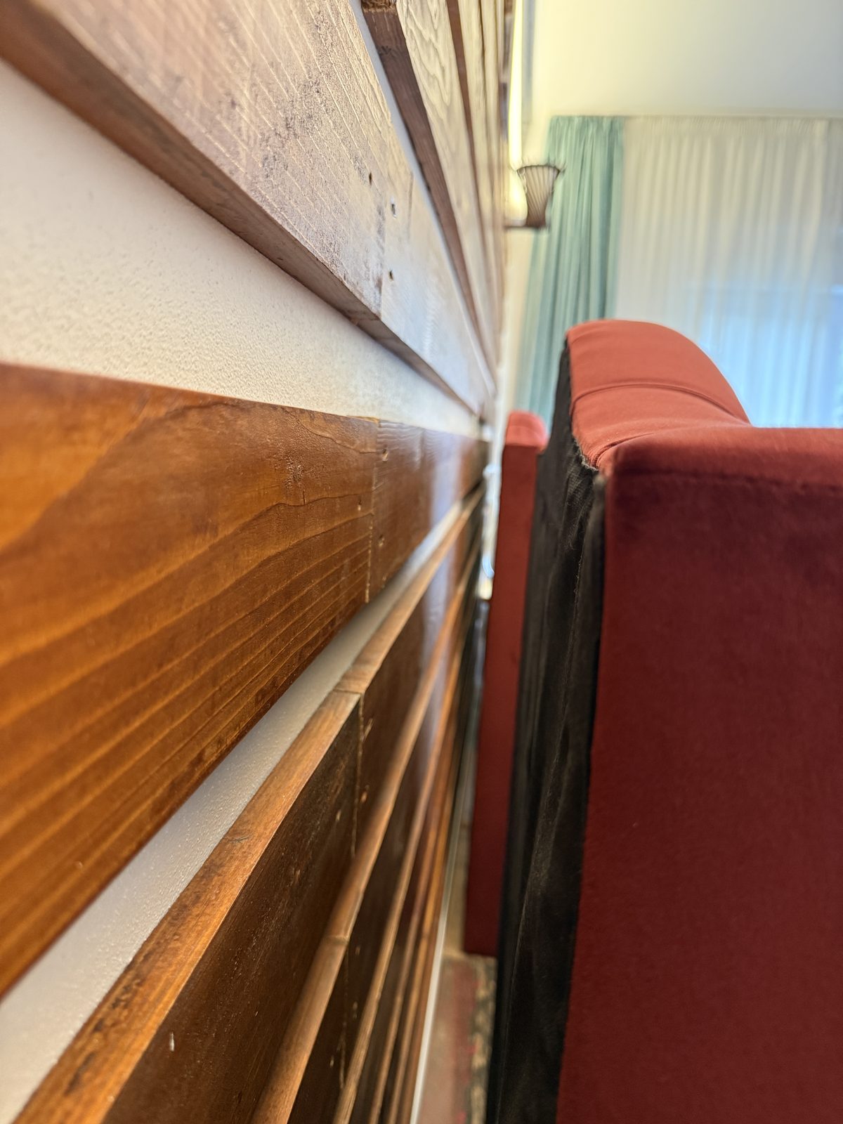 Close-up of wood-paneled headboard pulled away from the wall during a bed bug inspection